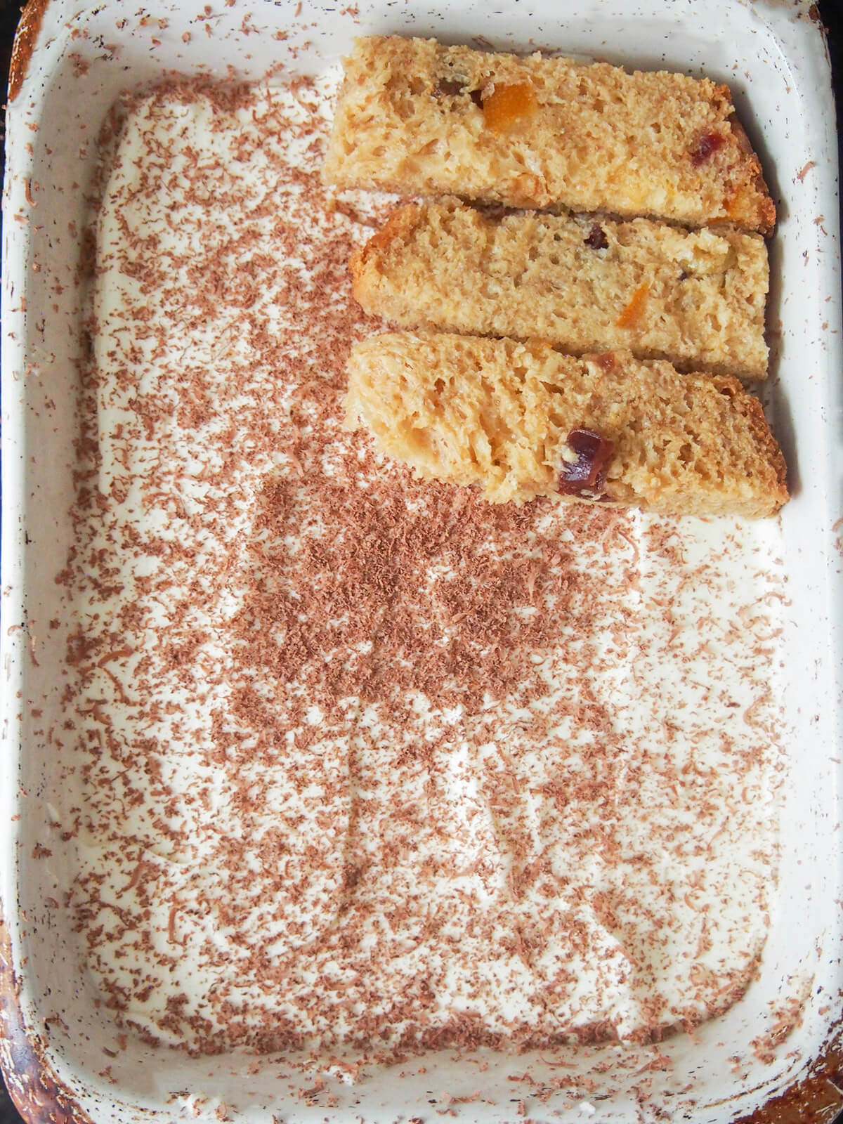 adding pieces of panettone on top of creamy layer with some grated chocolate on it.