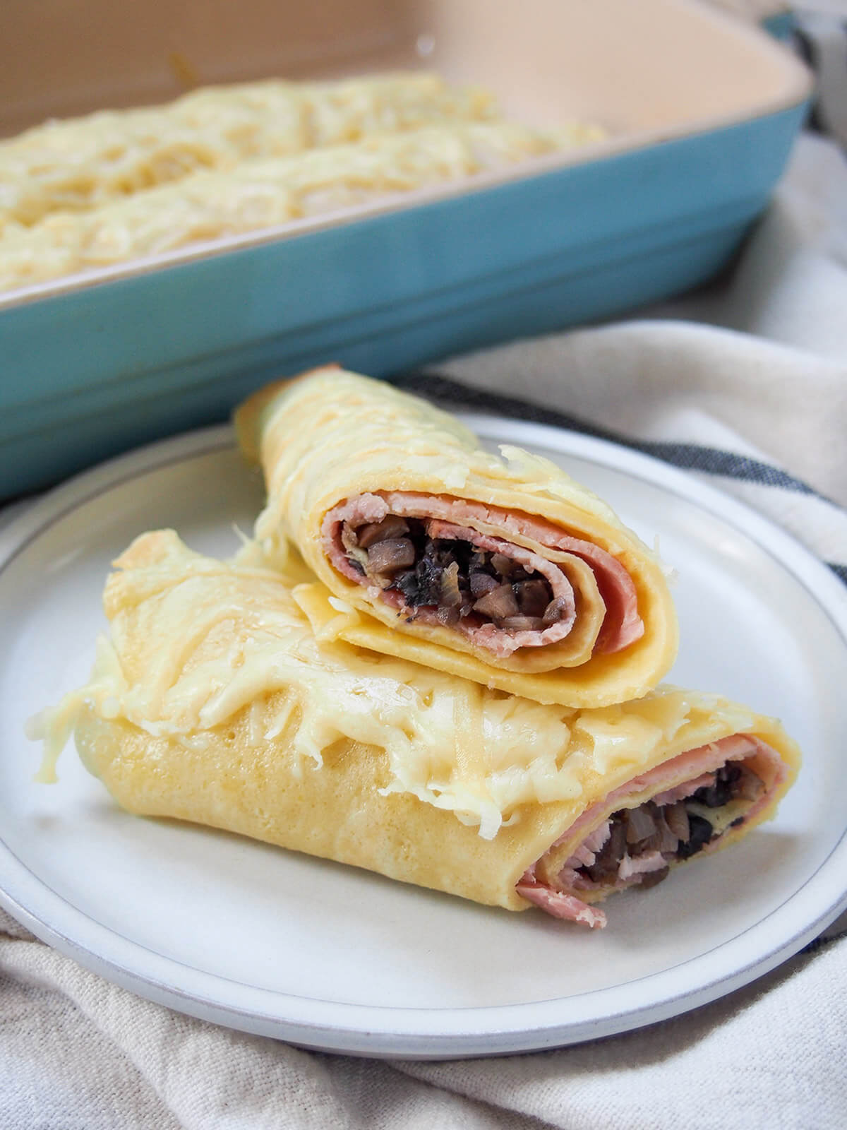cut ficelle picarde ham crepe gratin on plate in front of dish with more