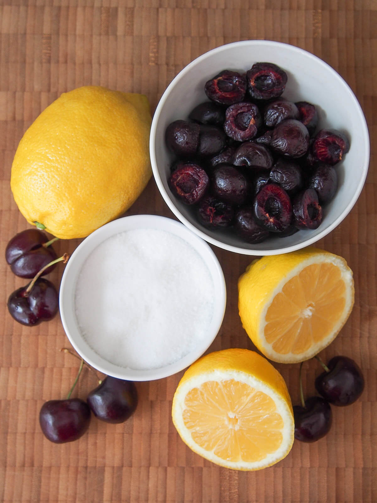 bowls of cherries, sugar and lemons to side