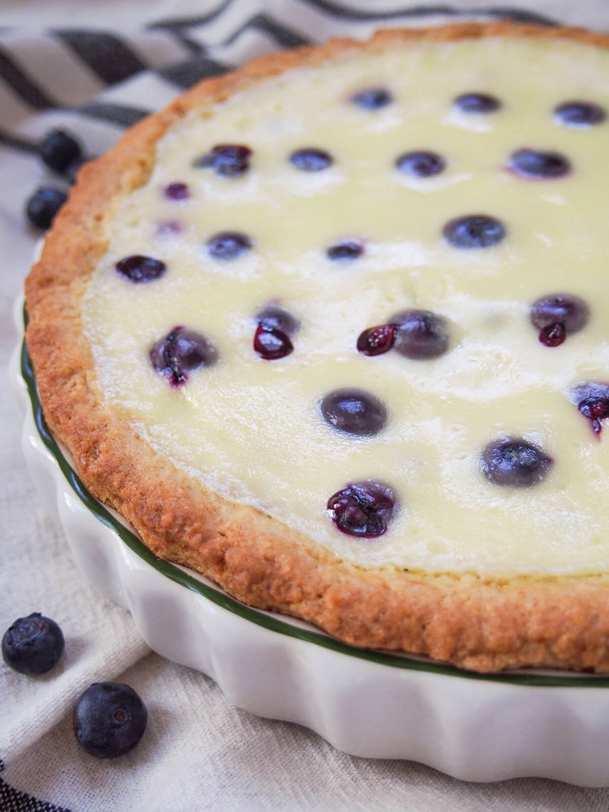 side view of Finnish blueberry pie showing just bursting from some of berries on top