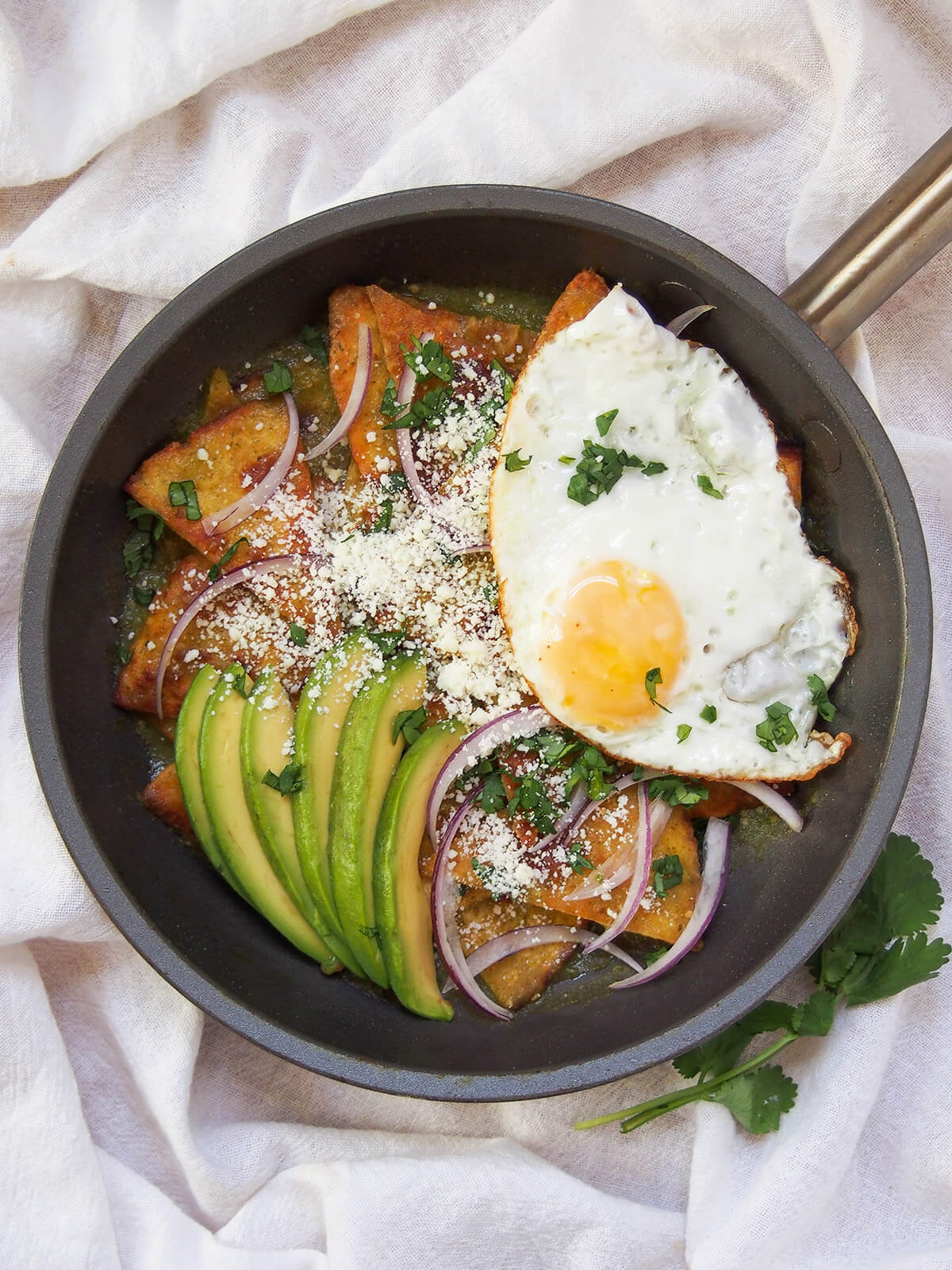 chilaquiles verdes in skillet with egg on top from overhead