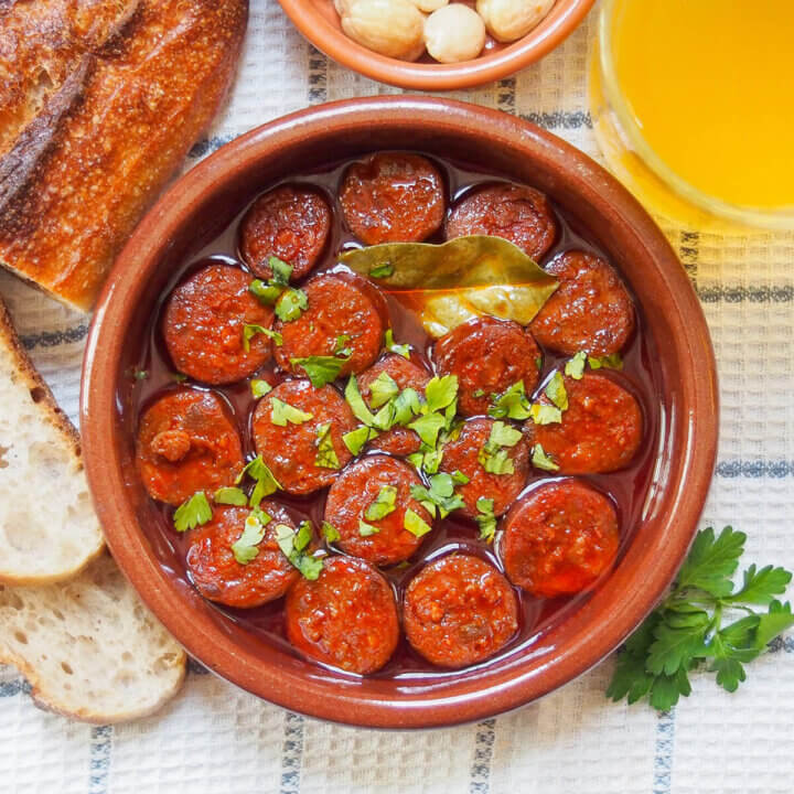 dish of chorizo a la sidra (chorizo in cider) with bay leaf in between slices