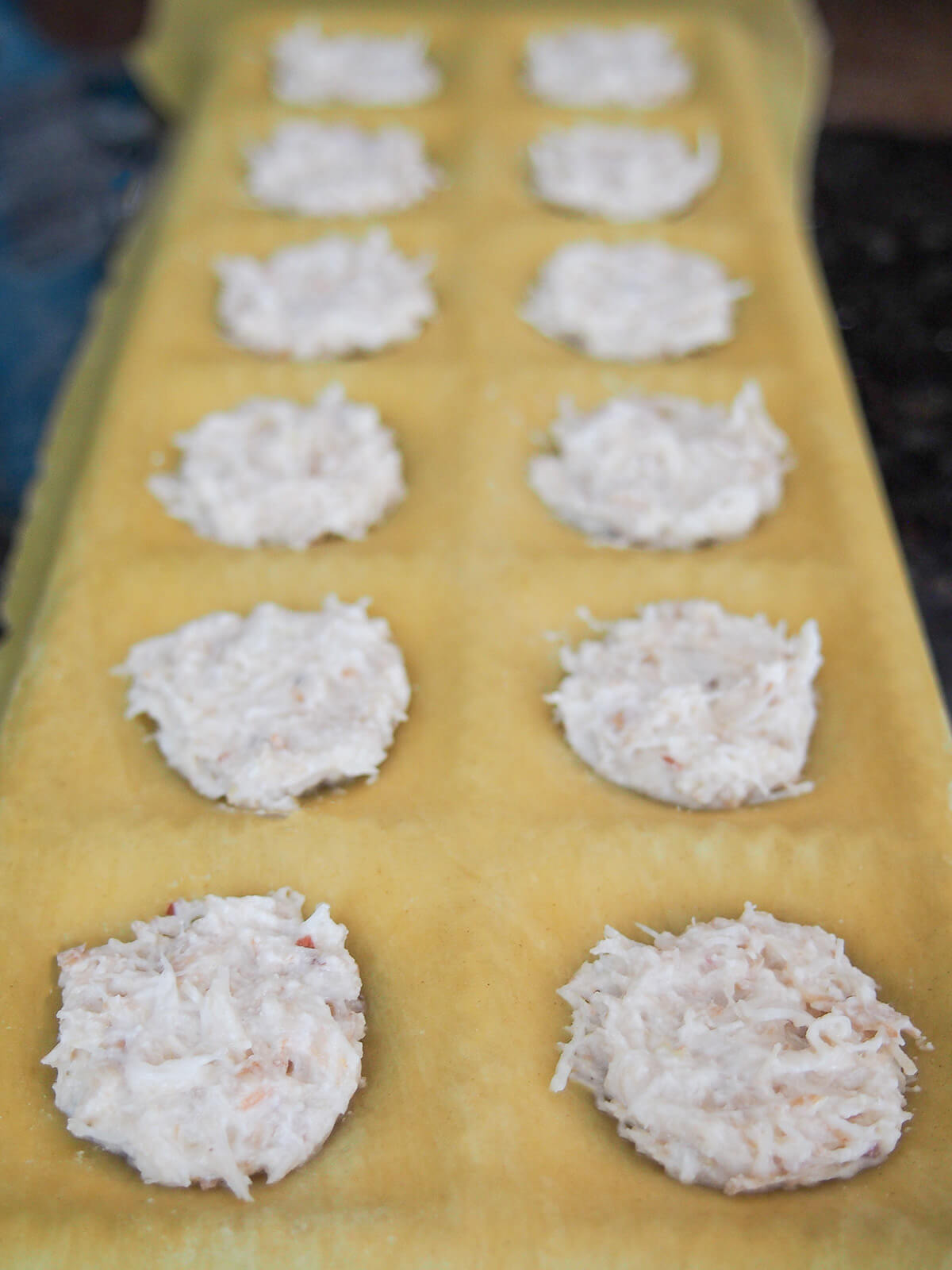 adding crab filling to pasta in mould