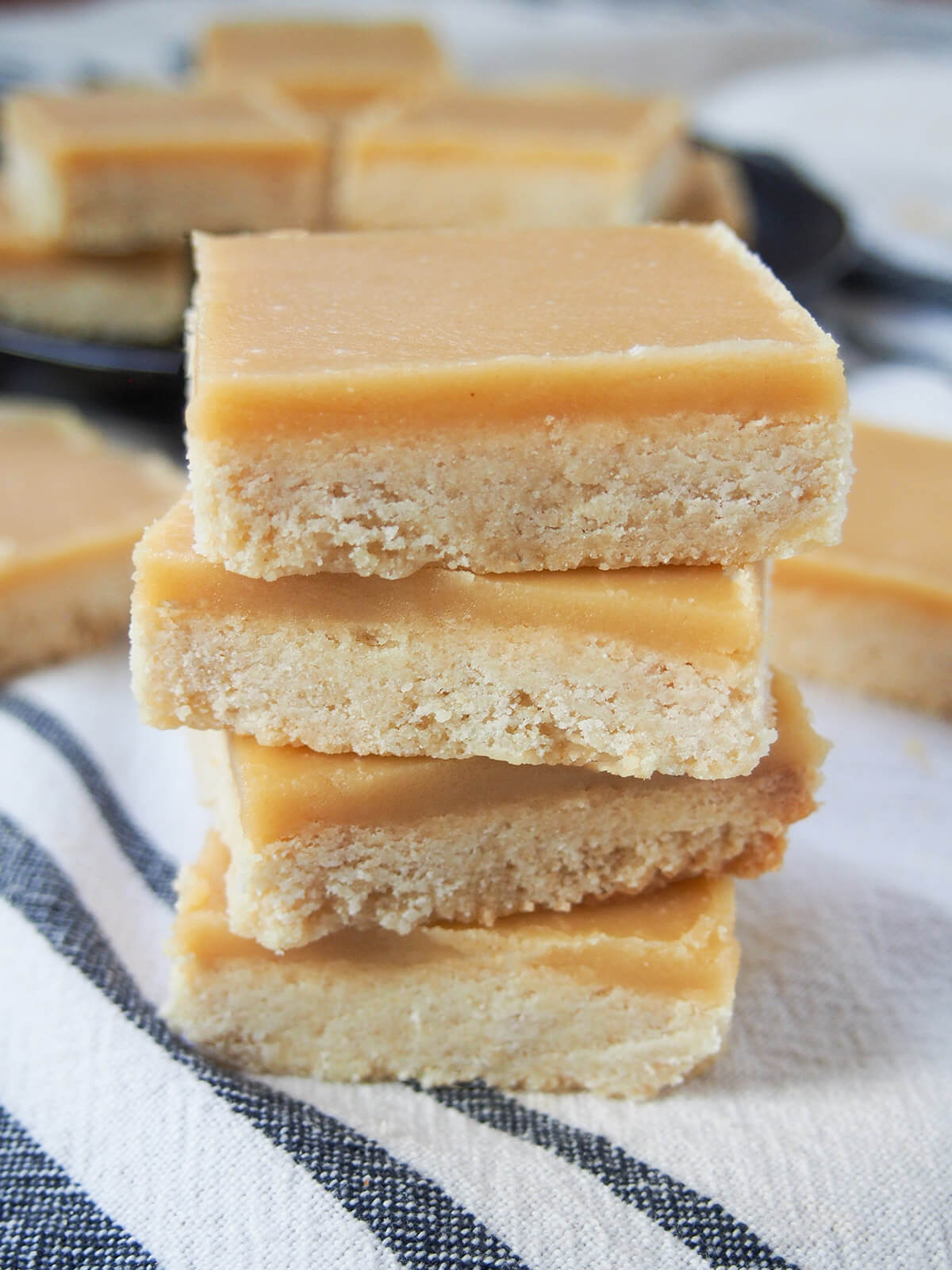 stack of ginger crunch slice showing layers of cookie and icing on top
