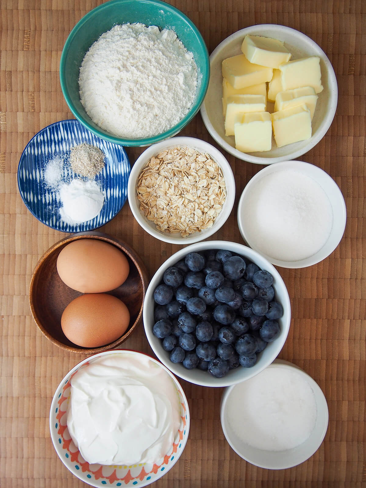 bowls of butter, flour, sugar, blueberries, oats, sour cream, eggs
