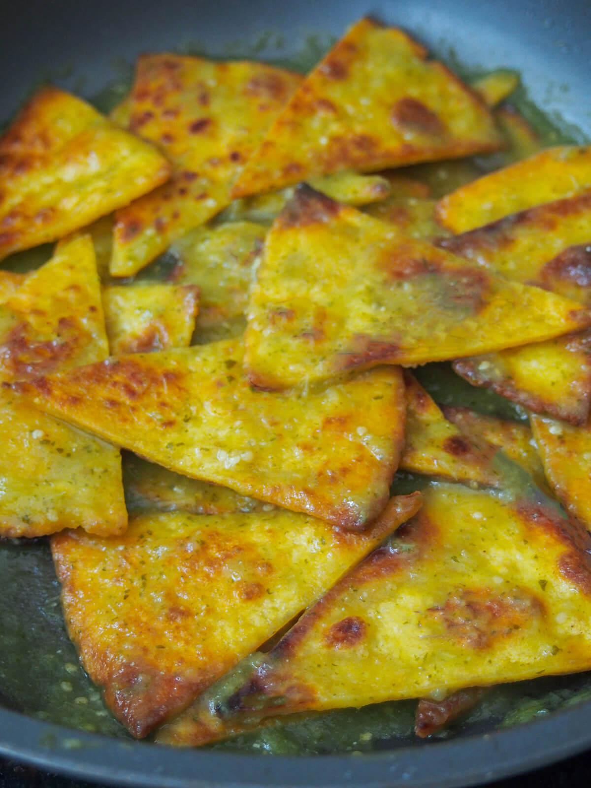 tossing tortilla chips in salsa verde