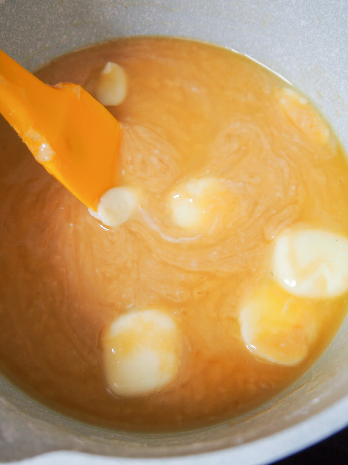 stirring butter into syrup and sugar liquid mixture