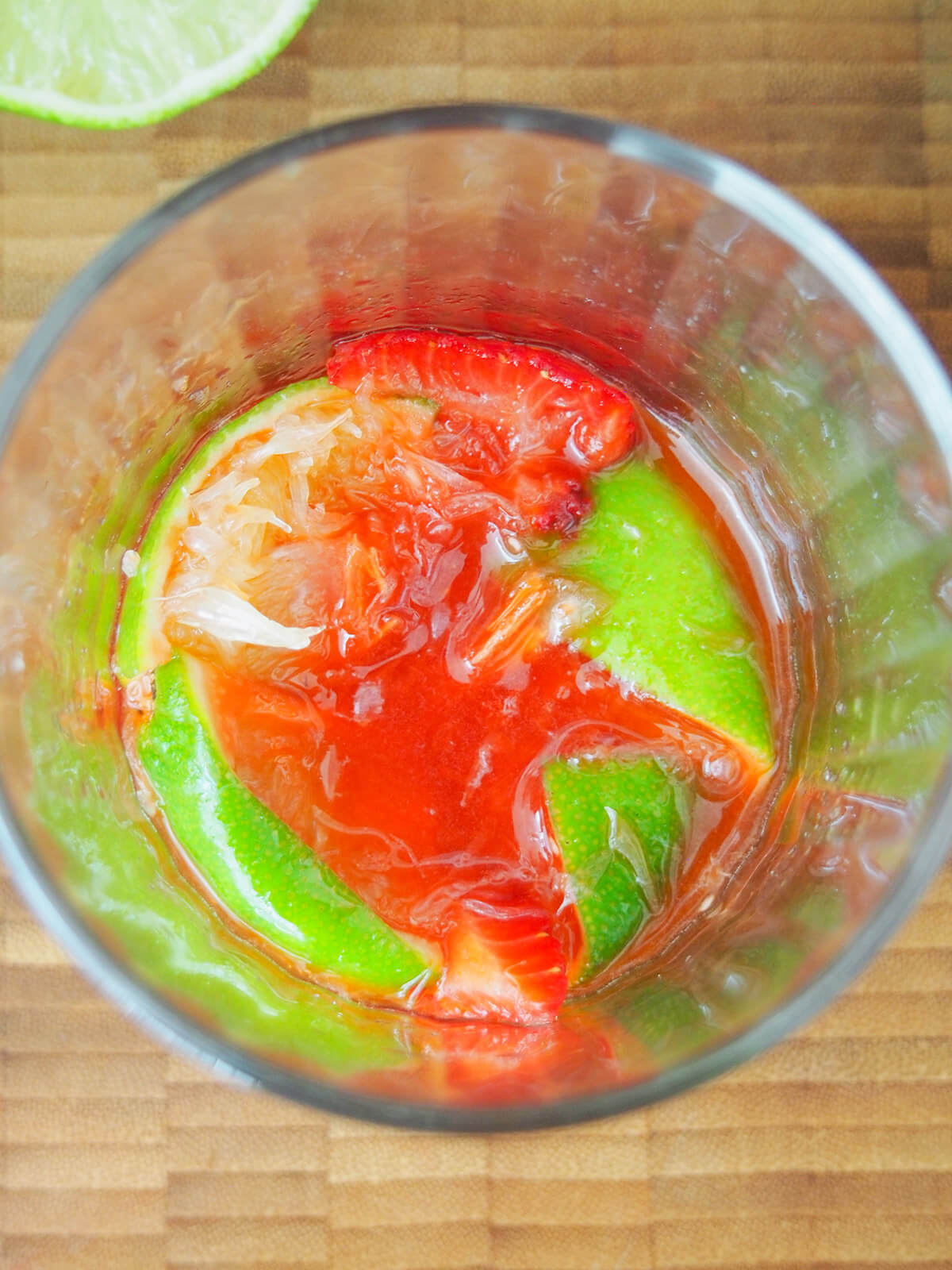 muddled strawberries and lime in glass
