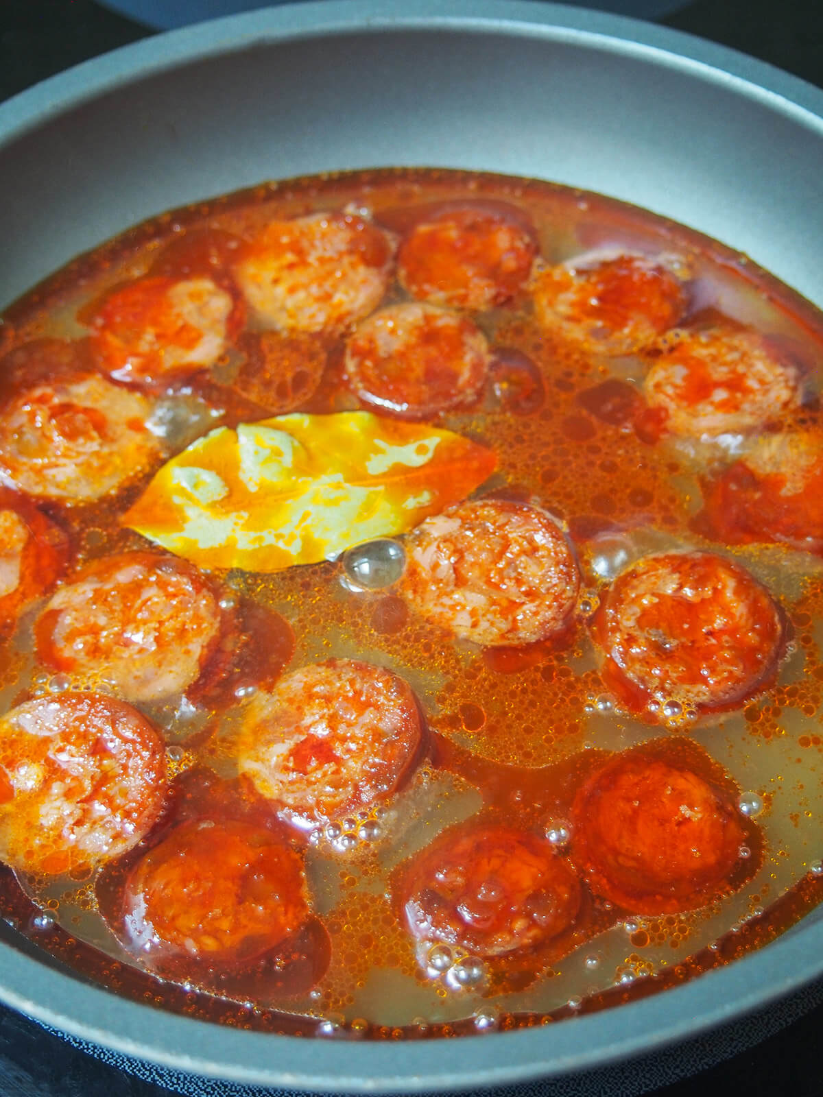 skillet with chorizo and cider starting to cook