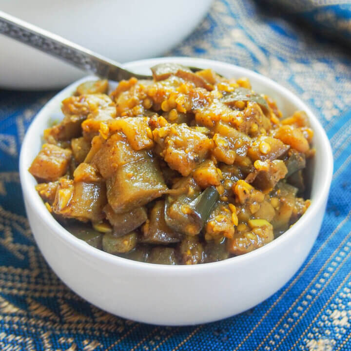 small bowl of brinjal pickle with spoon to back