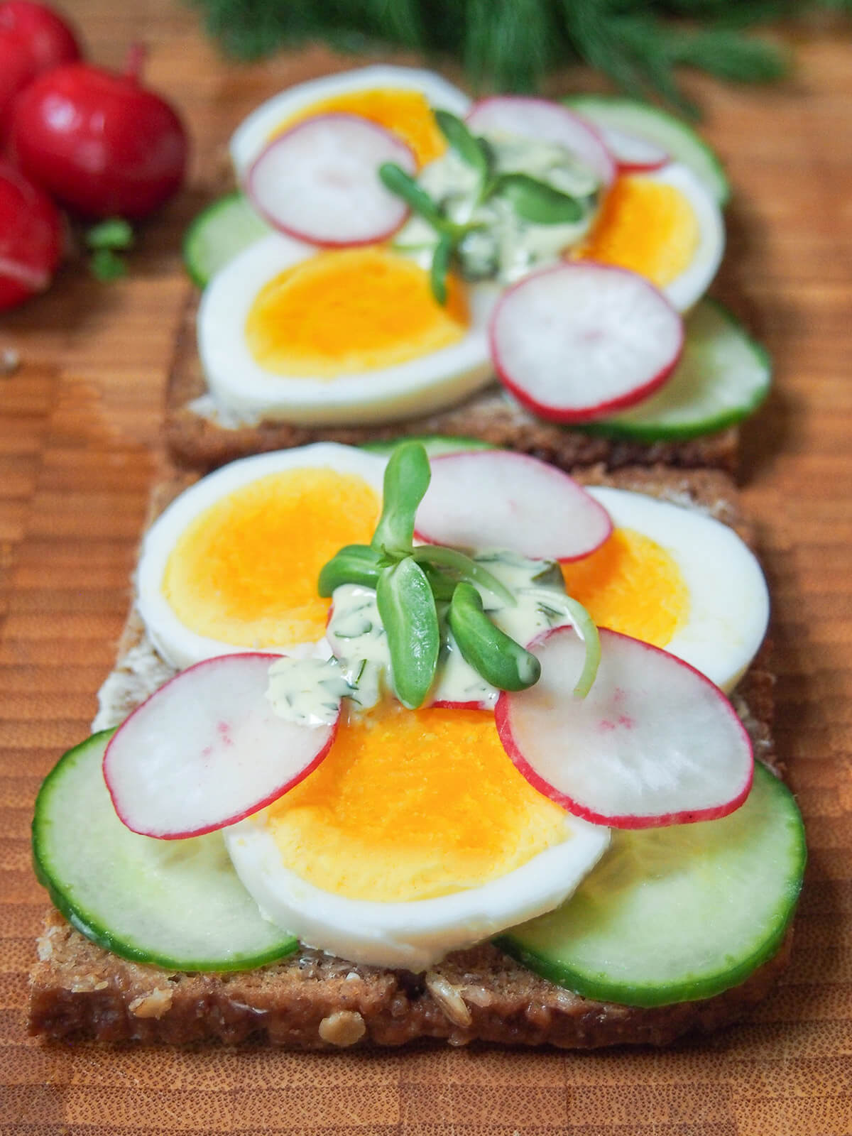 open sandwich with egg, radish and cucumber topping