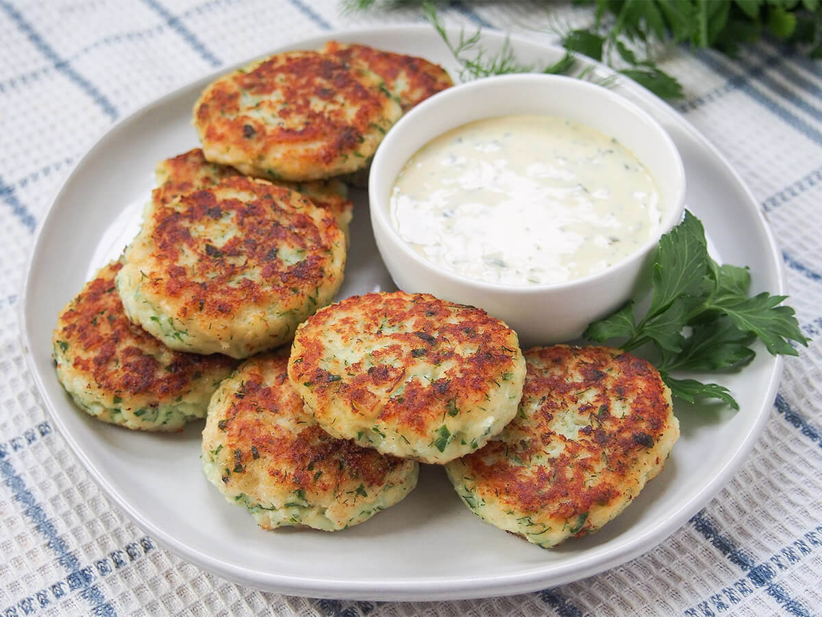fiskefrikadeller (Danish fish cakes) plate of fiskefrikadeller Danish fish cakes with remoulade in bowl behind