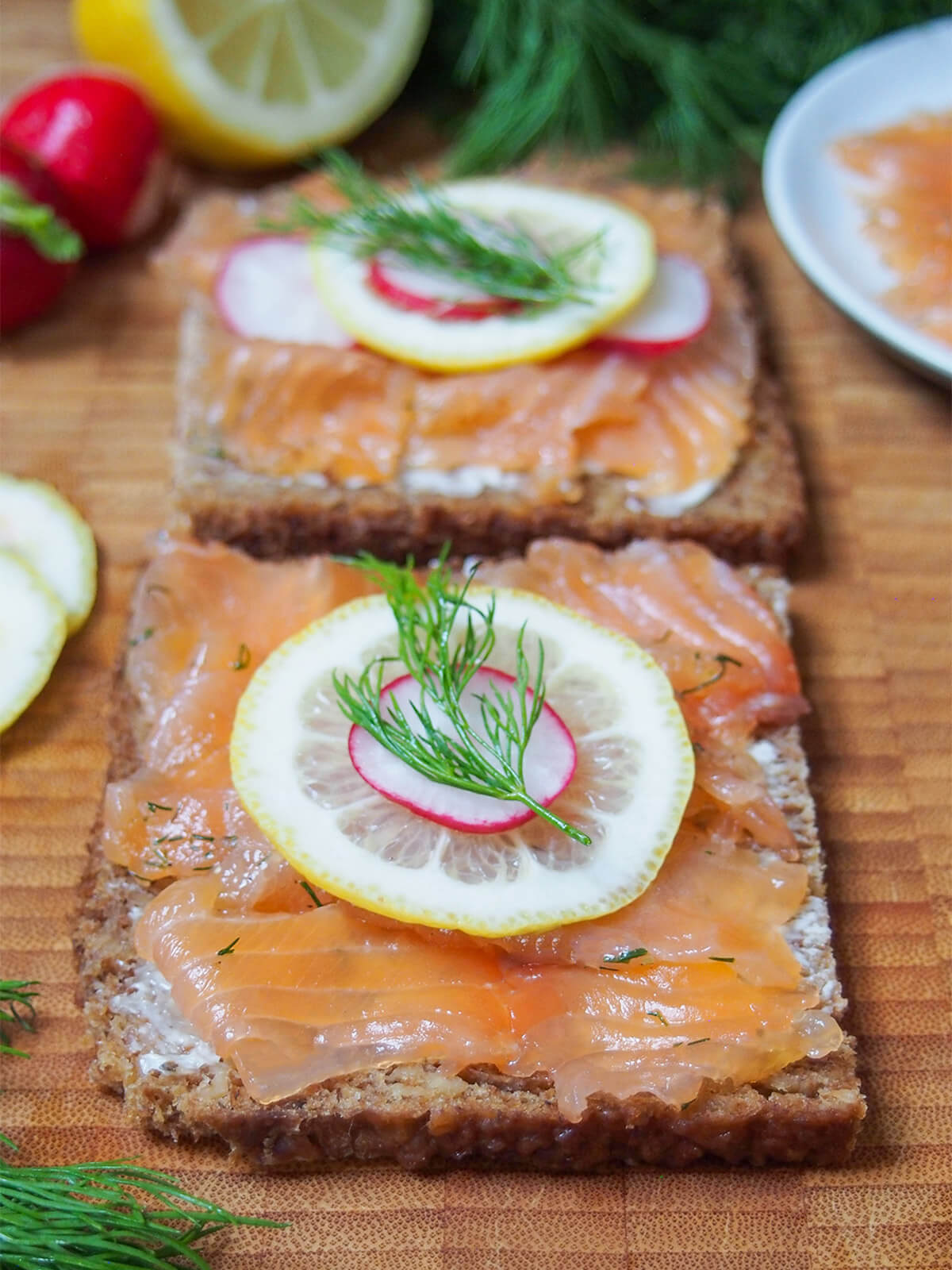 open sandwich topped with salmon gravlax and slice of lemon
