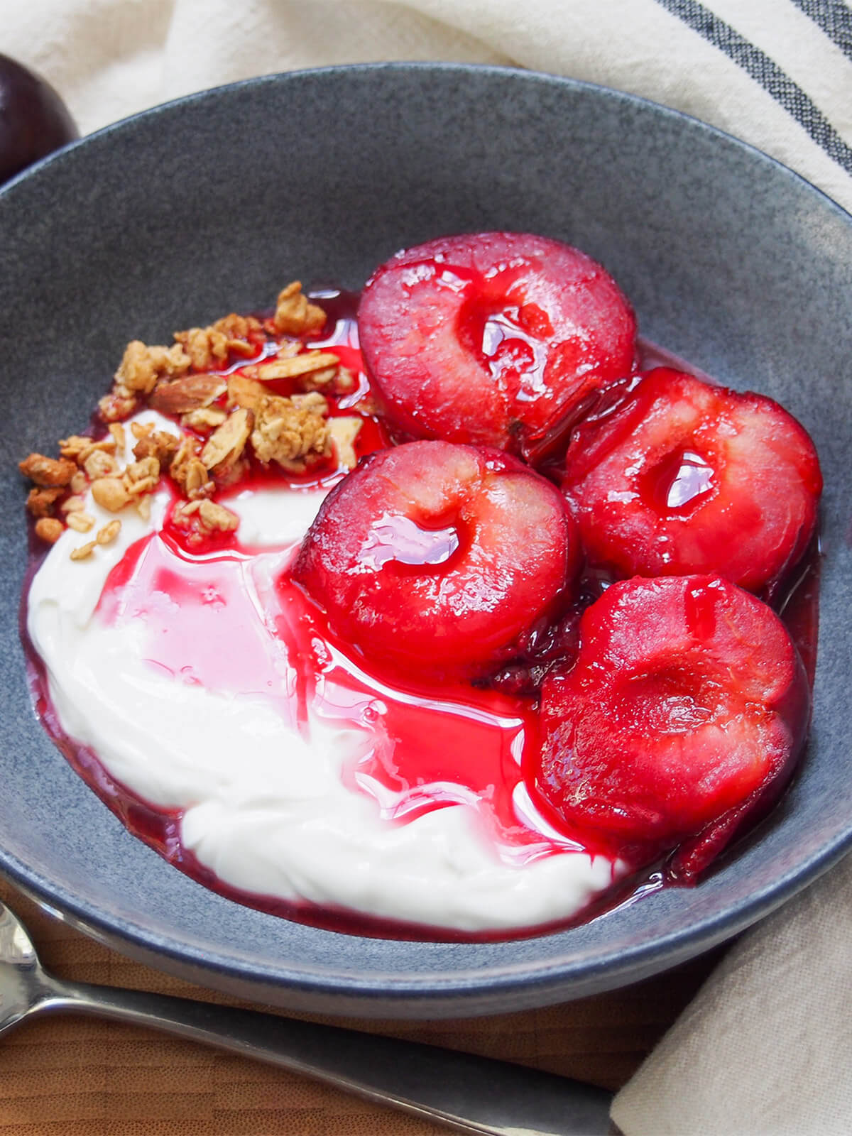 side close view of stewed plums over yogurt