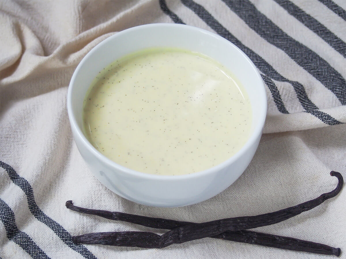 bowl of Vanillesosse German vanilla sauce with two whole vanilla pods below