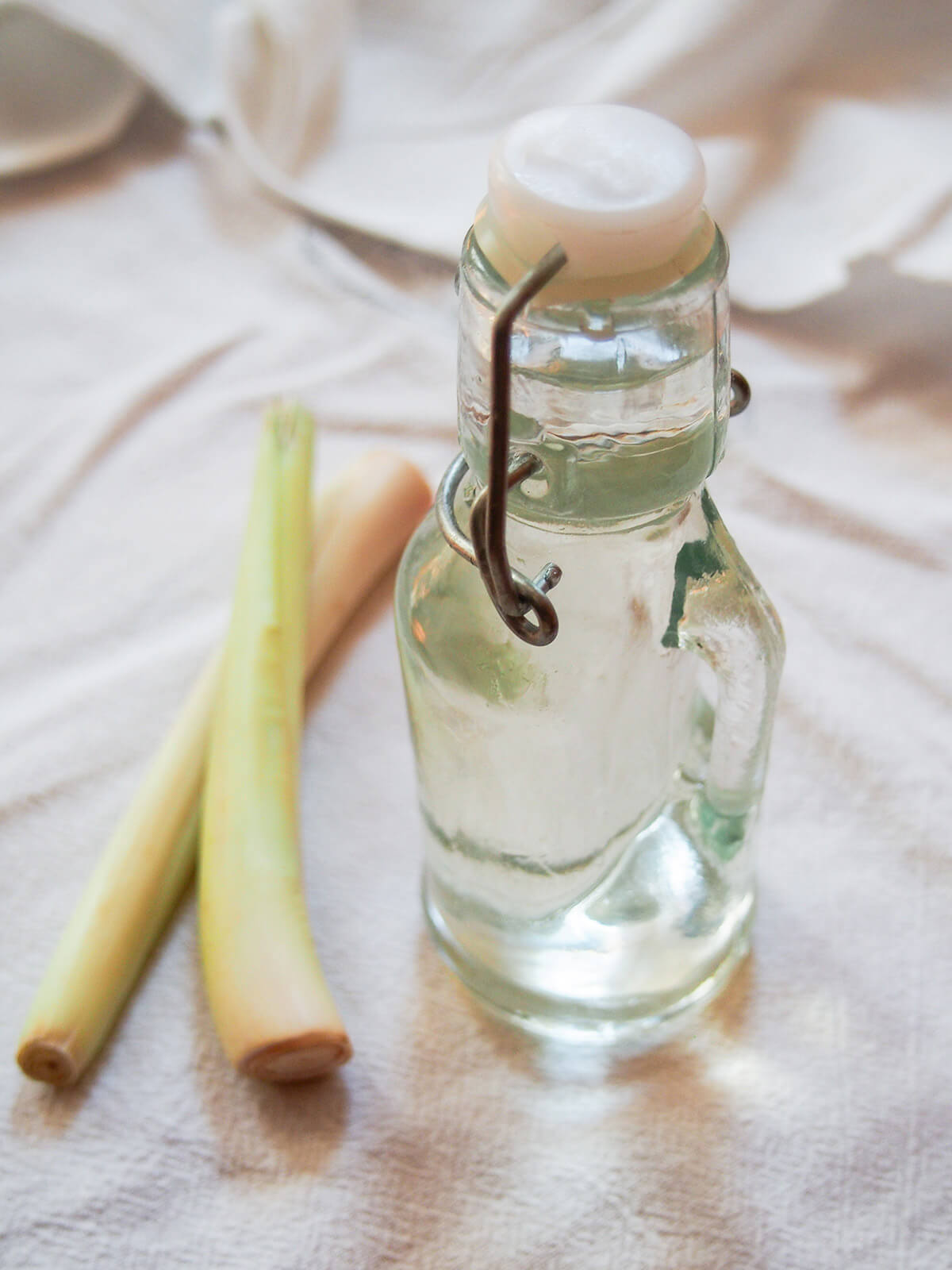 bottle of lemongrass syrup with two sticks of lemongrass to side