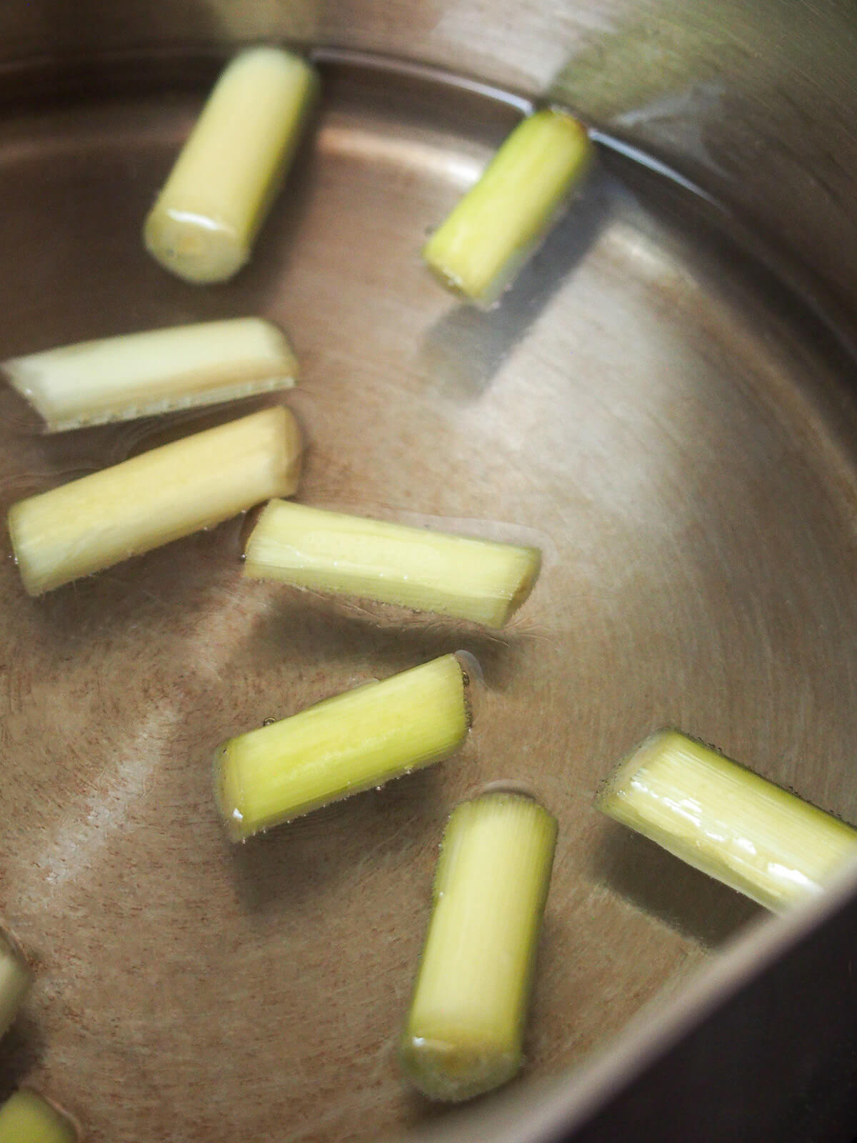 pieces of lemongrass in pan with sugar dissolved