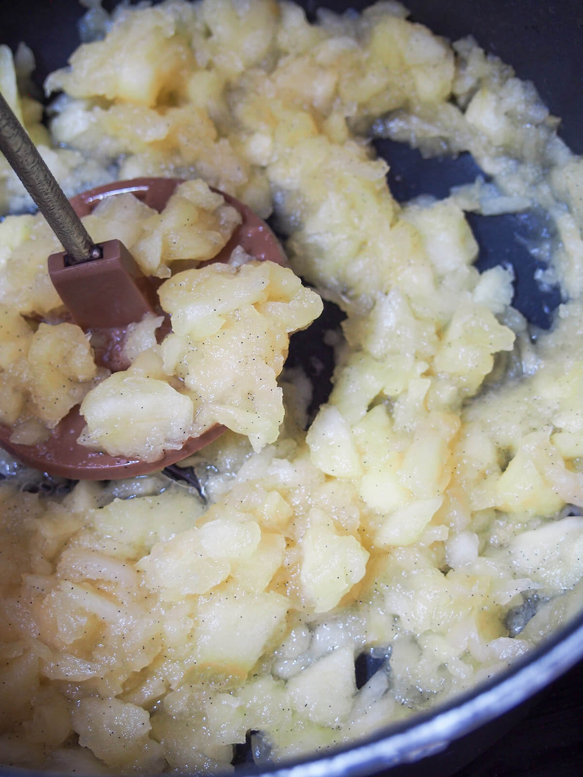 mashing softened apple with vanilla