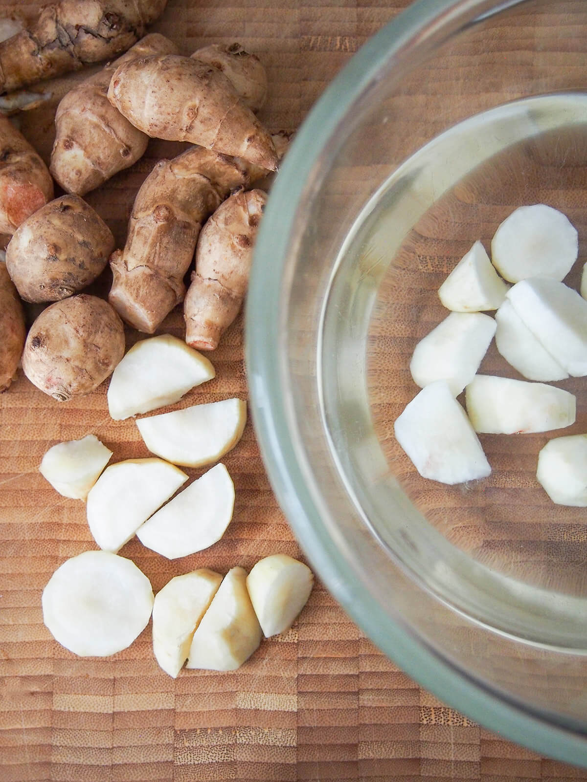 chopping and placing chunks of Jerusalem artichoke in bowl of water