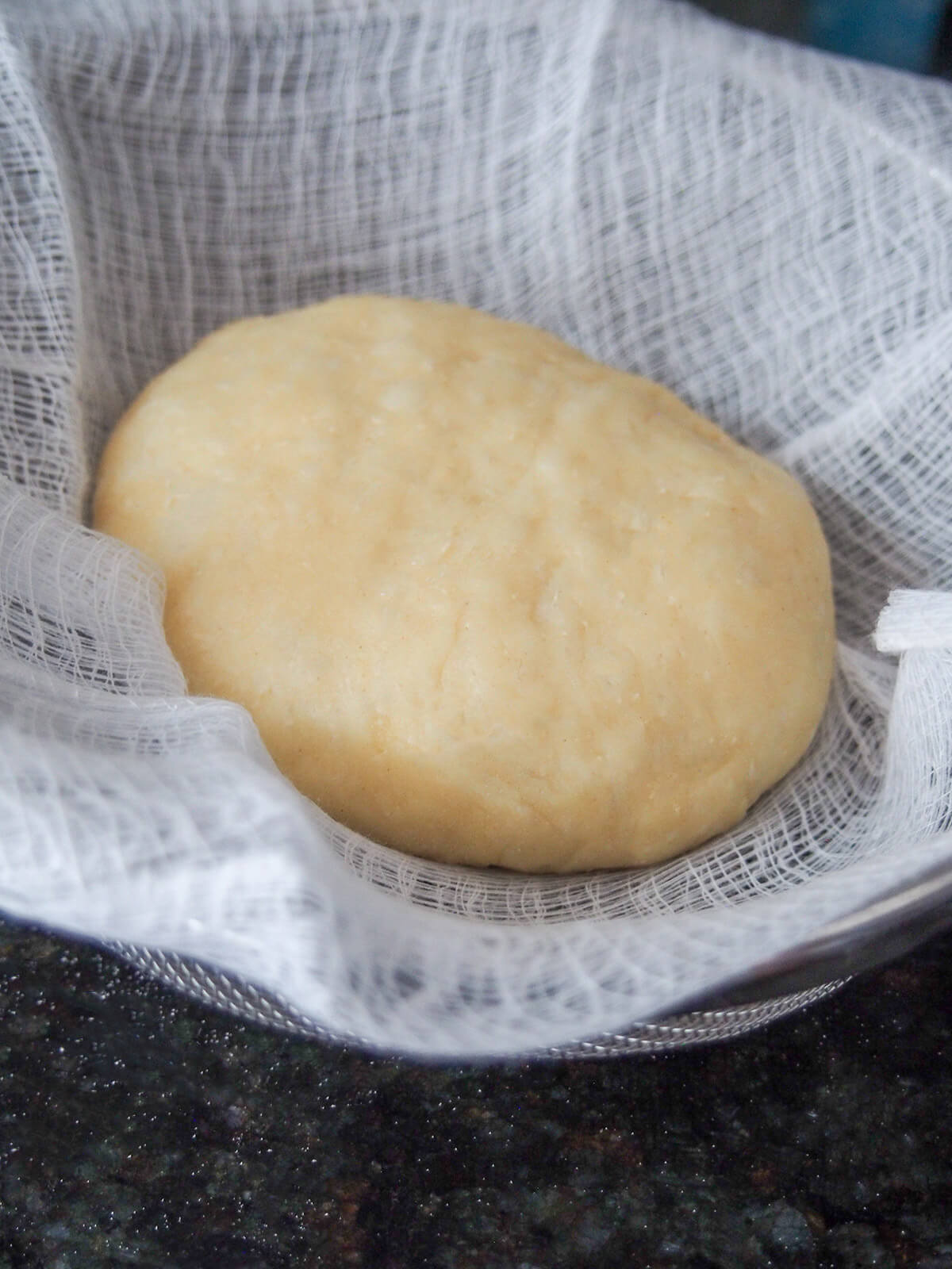 Germknödel before cooking uncooked dumpling in lined sieve ready to steam.