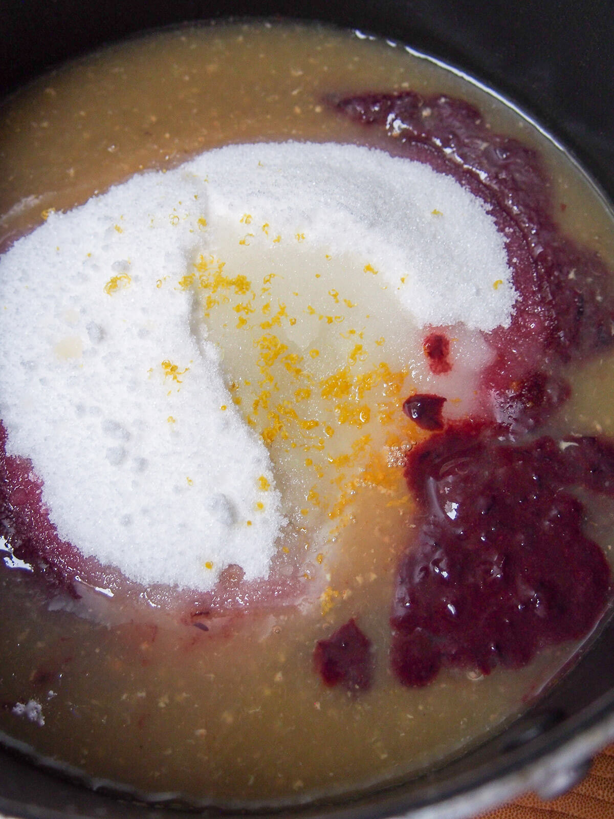 ingredient for Concord grape jam in pot grape pulp, skin mixture and sugar in pot before stirring