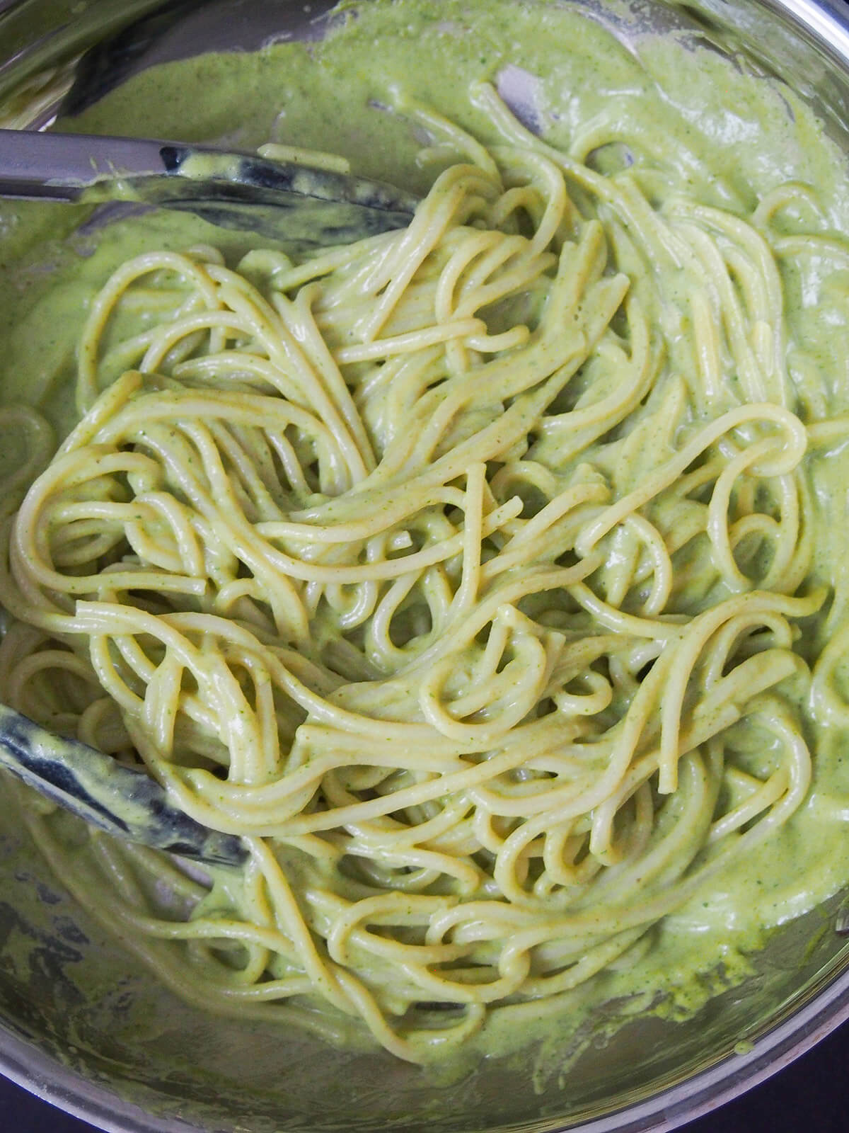 mixing cooked pasta into sauce