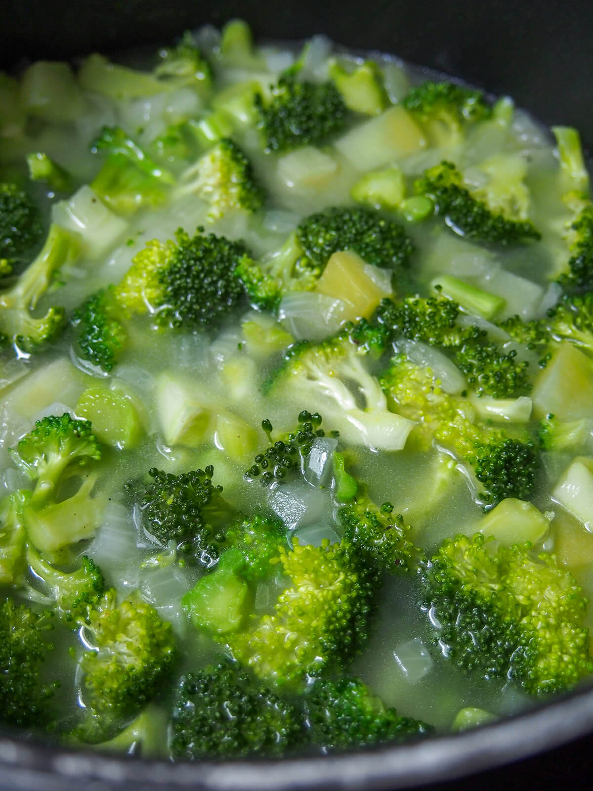 broccoli, potato and onions in pot with stock added before cooking further.