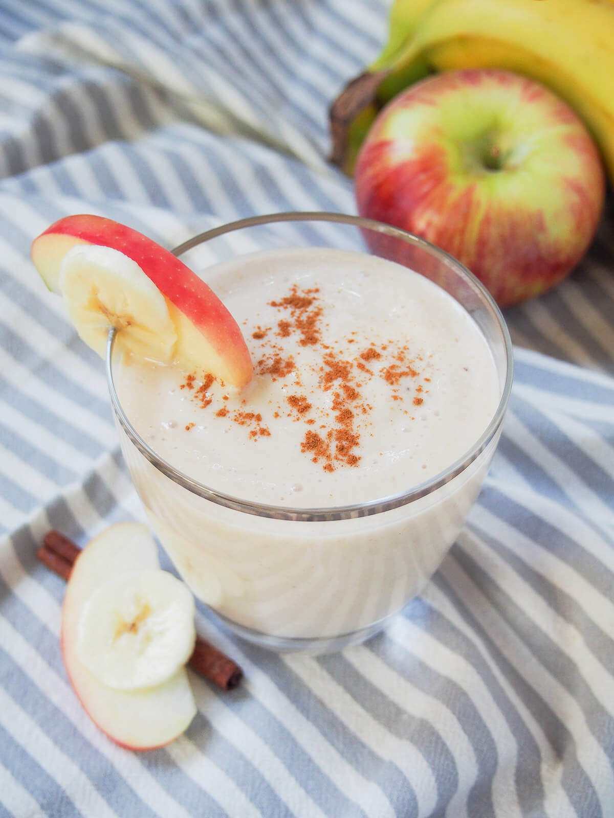 apple banana smoothie - easy to make with ingredients you're likely to have around the house. And tastes almost like apple pie! glass of apple banana smoothie garnished with slices of apple and banana.