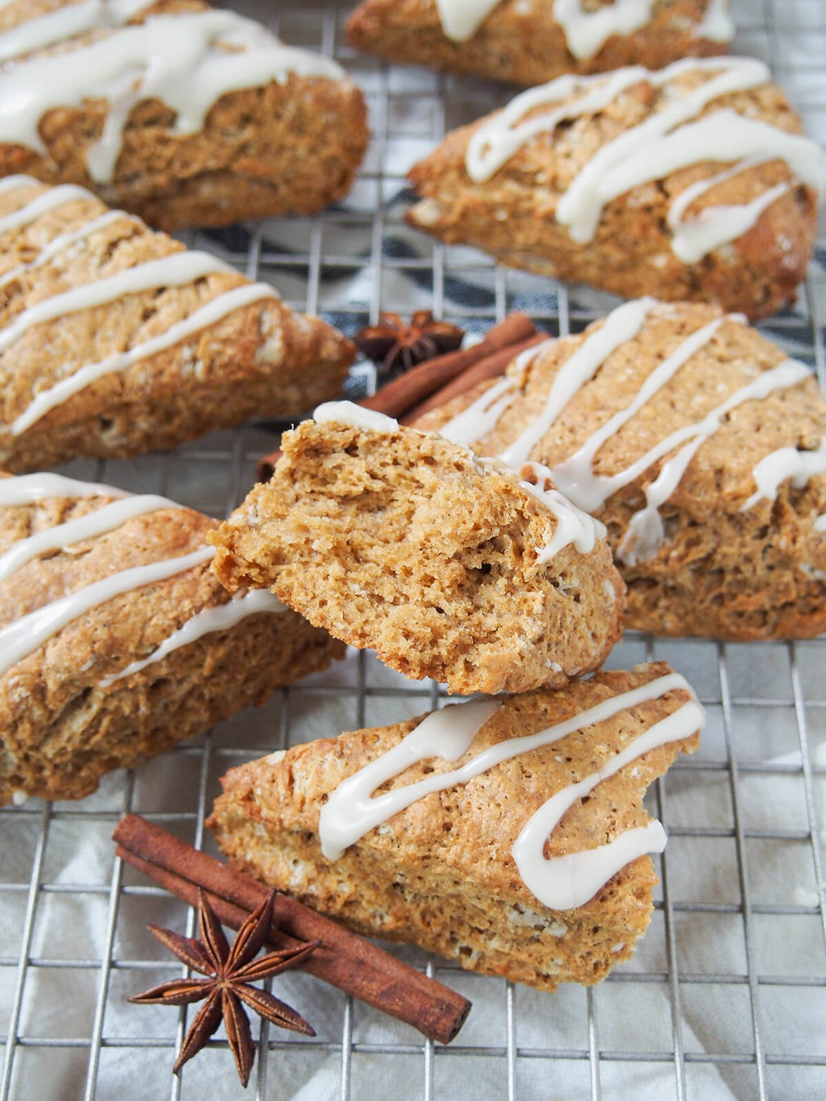 torn gingerbread scone sitting on top of other scones with spices in front.