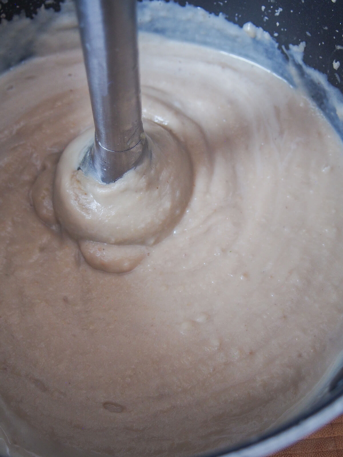 stick blender in soup, blending it up.