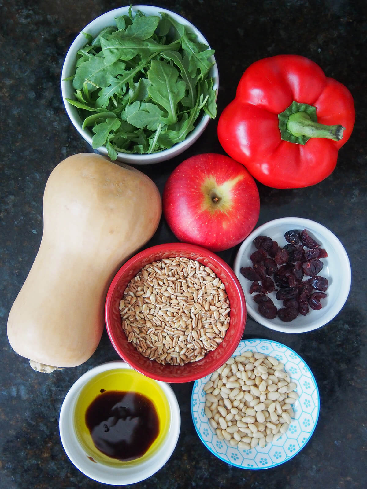 butternut squash, pepper, apple and bowls with arugula, cranberries, pine nuts, farro and oil and balsamic