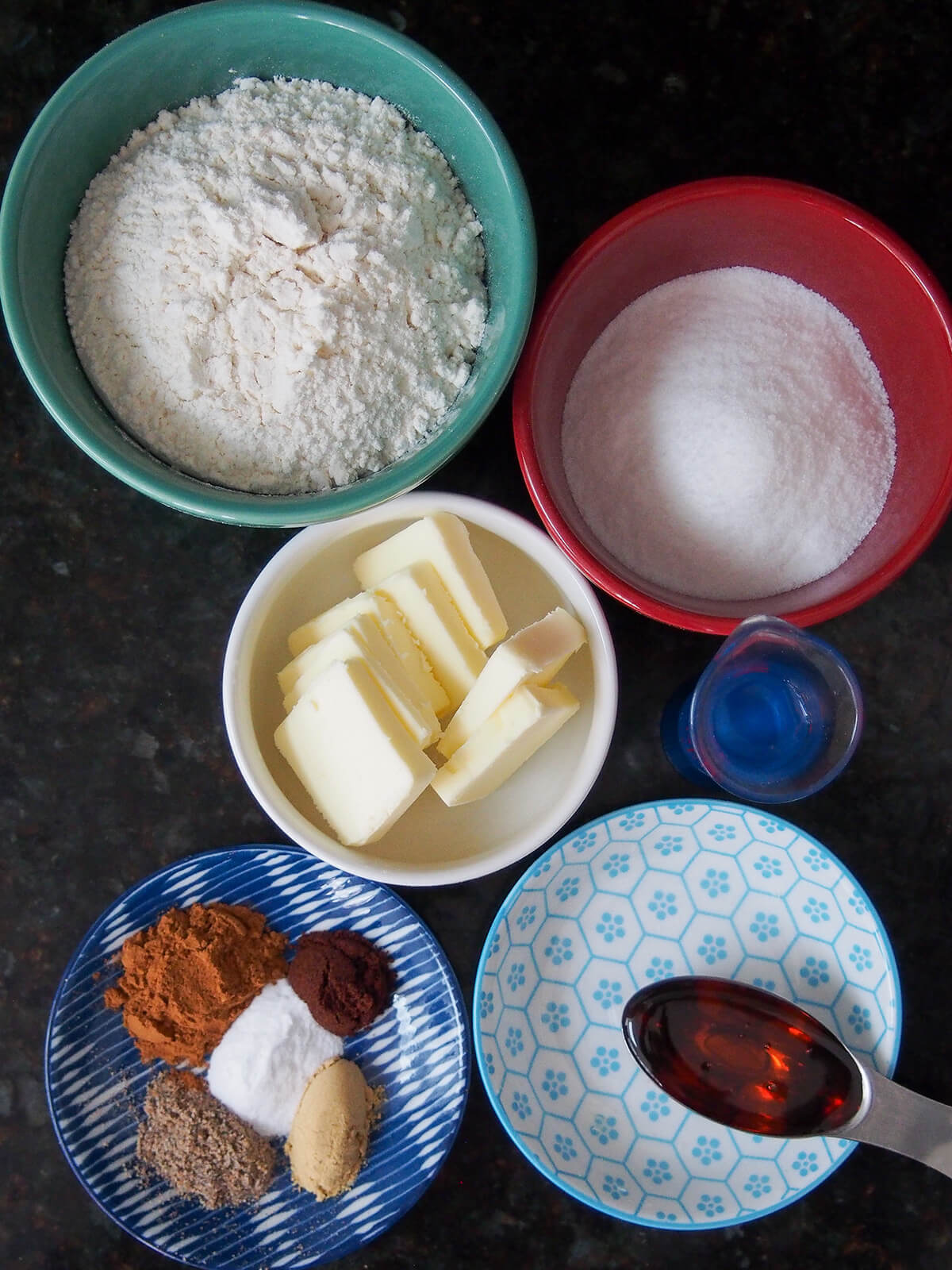 bowls with flour, sugar, butter spices and golden syrup from overhead.