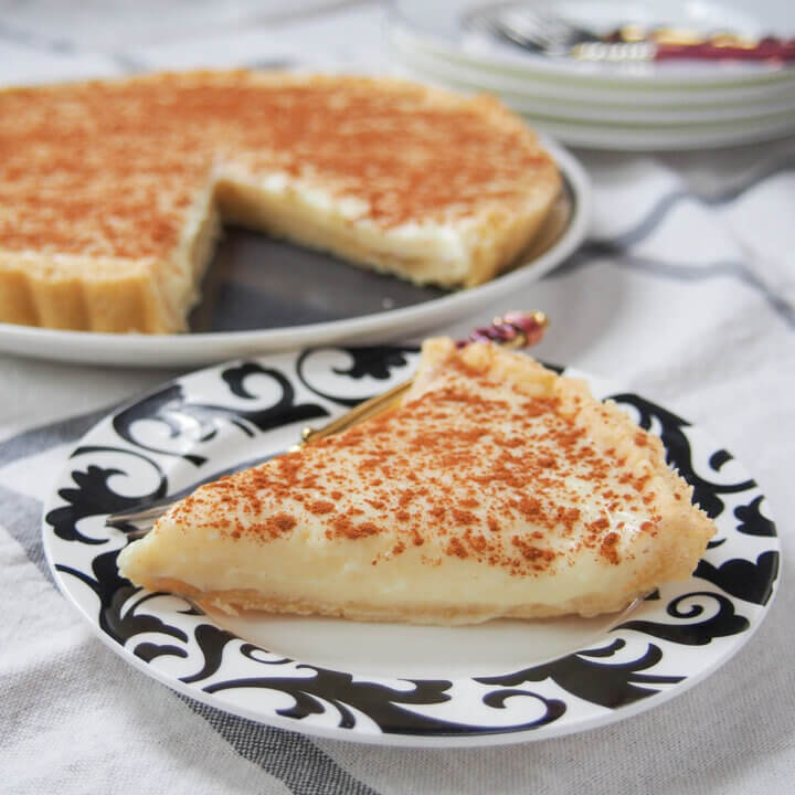 slice of milk tart (melktert) in front of rest of tart.
