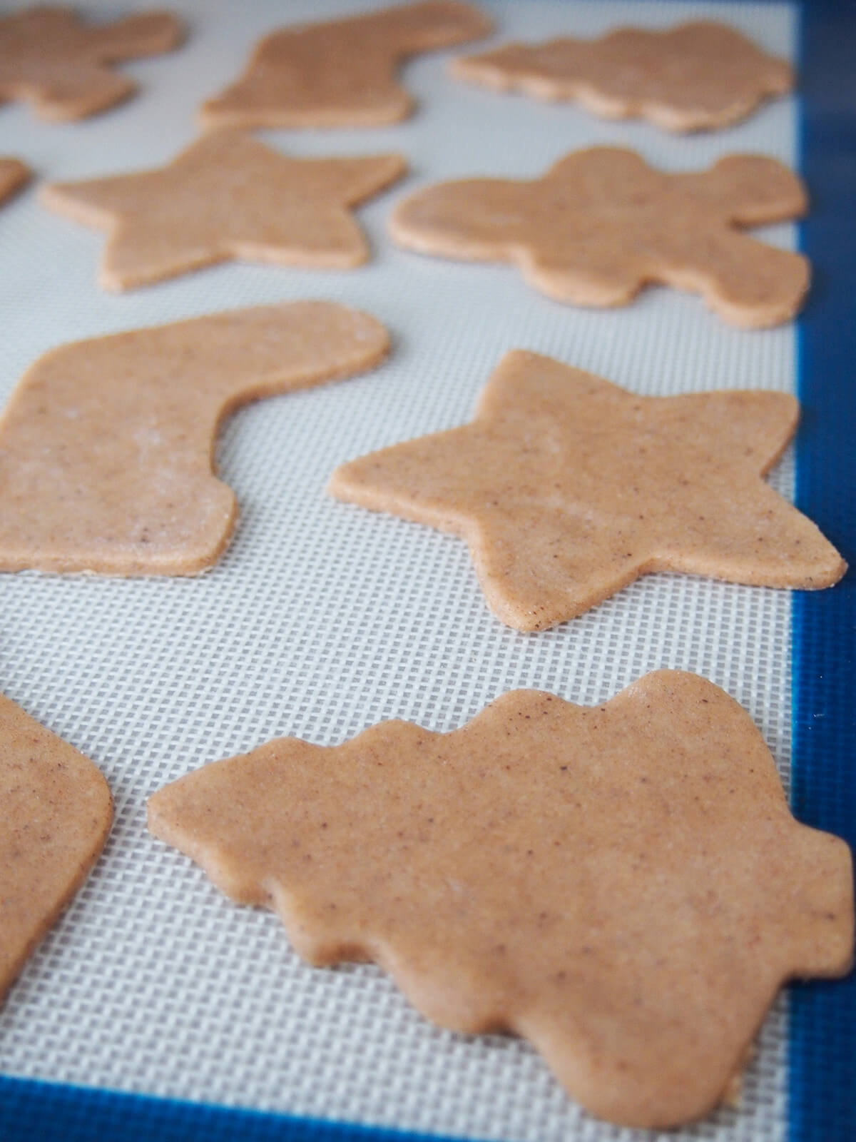 thin cookies cut out on lined baking sheet before baking.