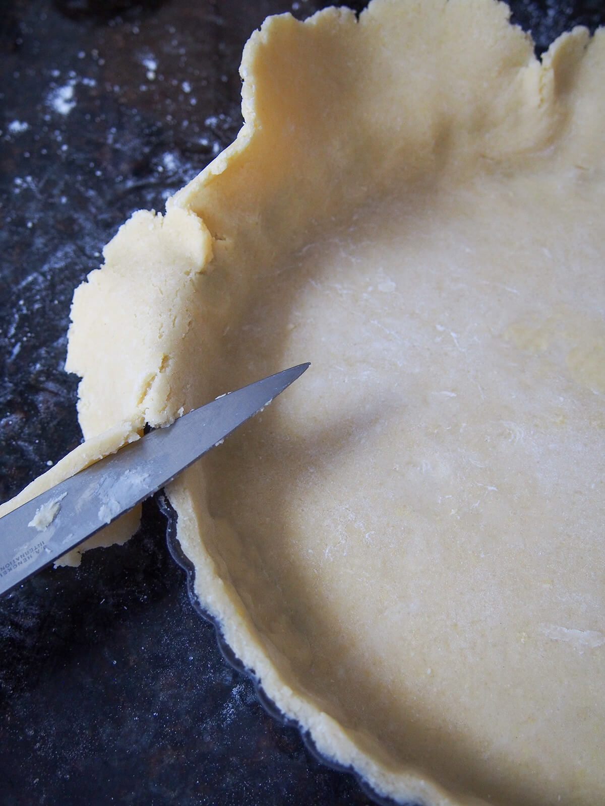 trimming edge from pastry in tart tin