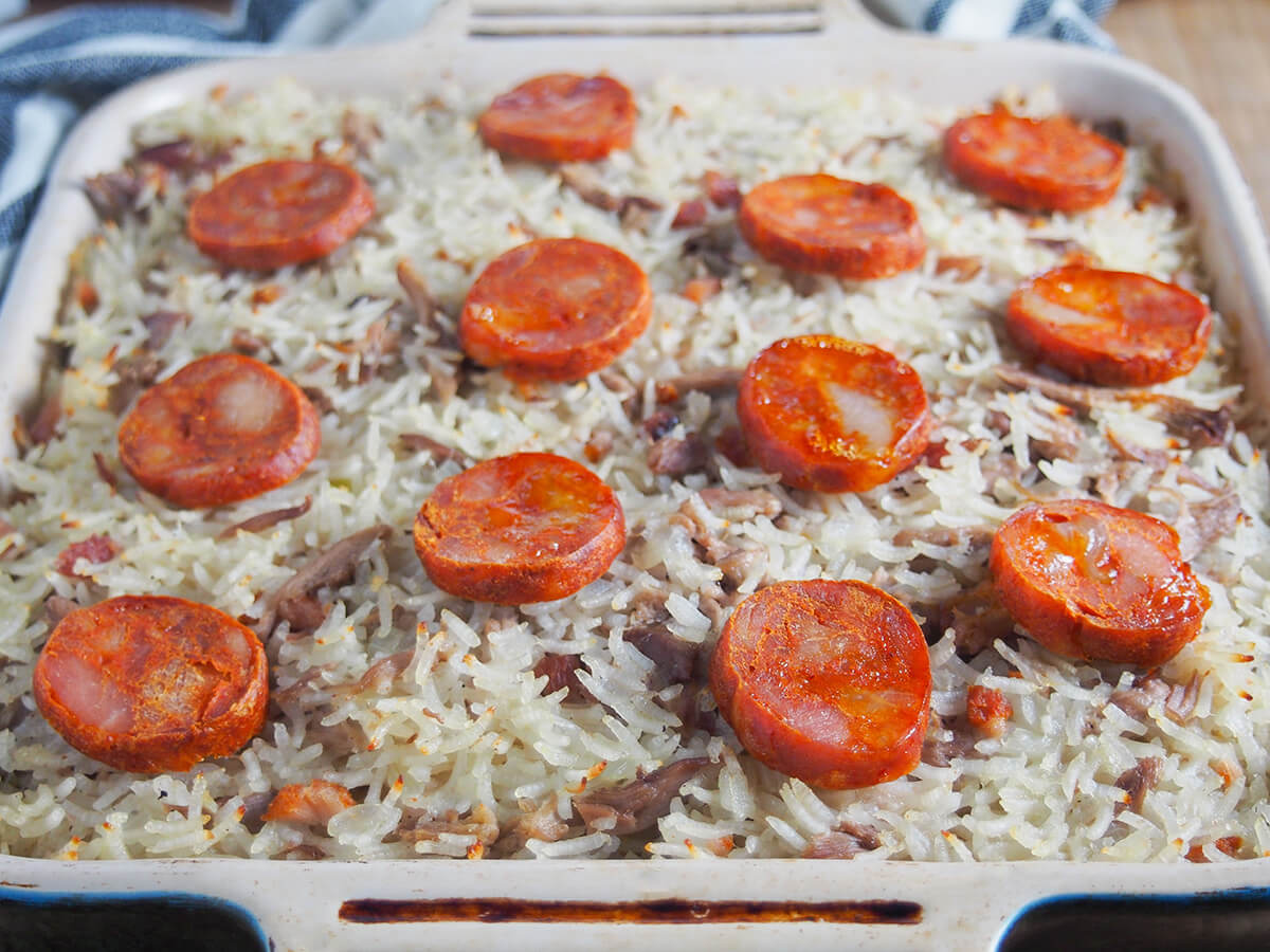 dish of arroz de pato Portuguese duck rice with slices of chorico over top.
