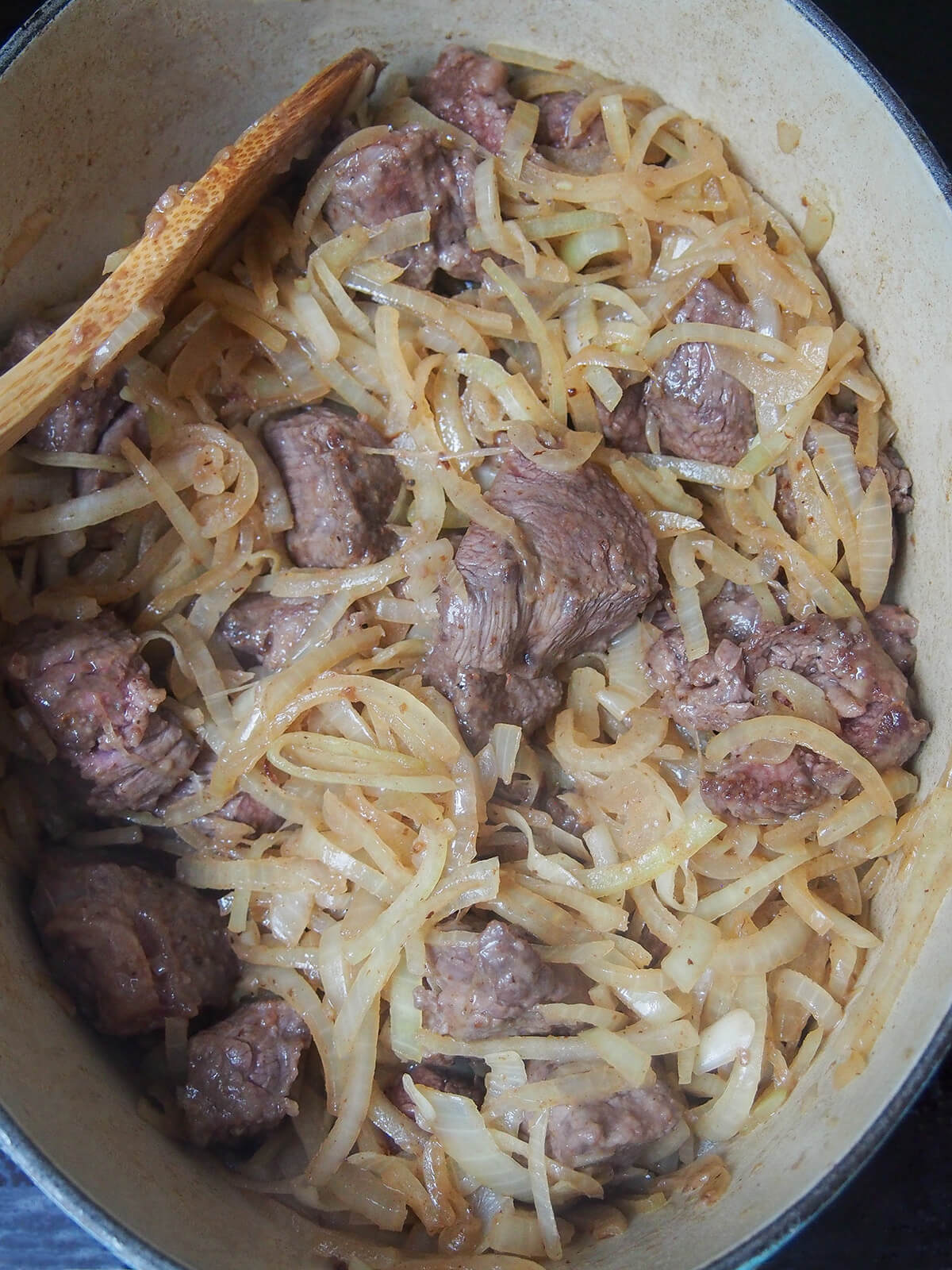 browned beef and softened onions in pot