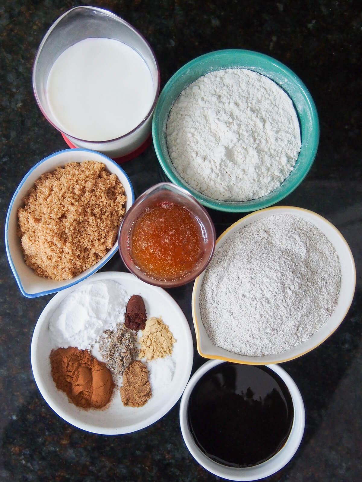 bowls of flour, milk, molasses, honey, sugar and spices.