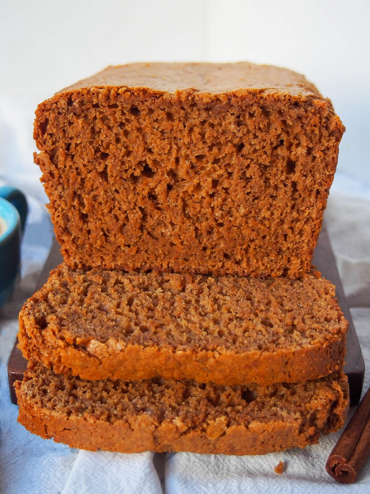 end on view of loaf of ontbijtkoek Dutch spice cake with slices flat in front.