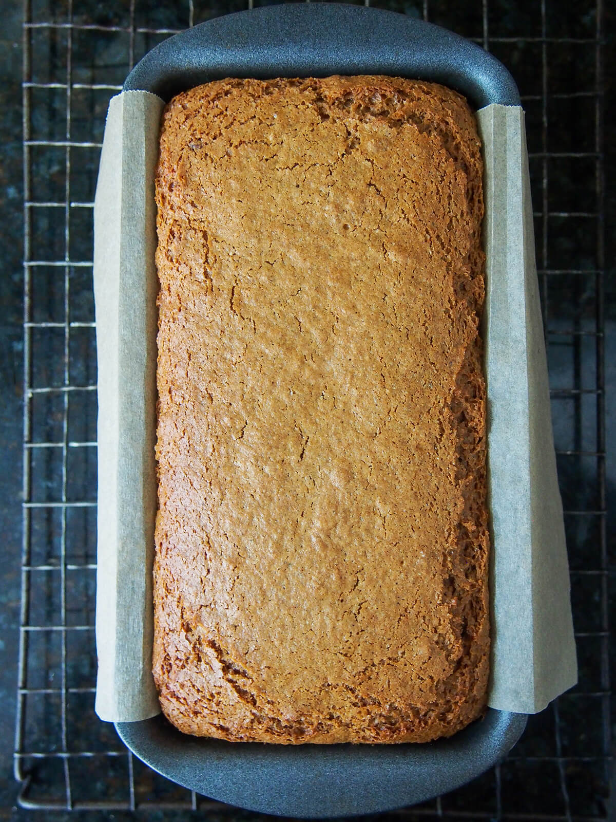 ontbijtkoek Dutch spice cake in loaf tin cooling on rack.