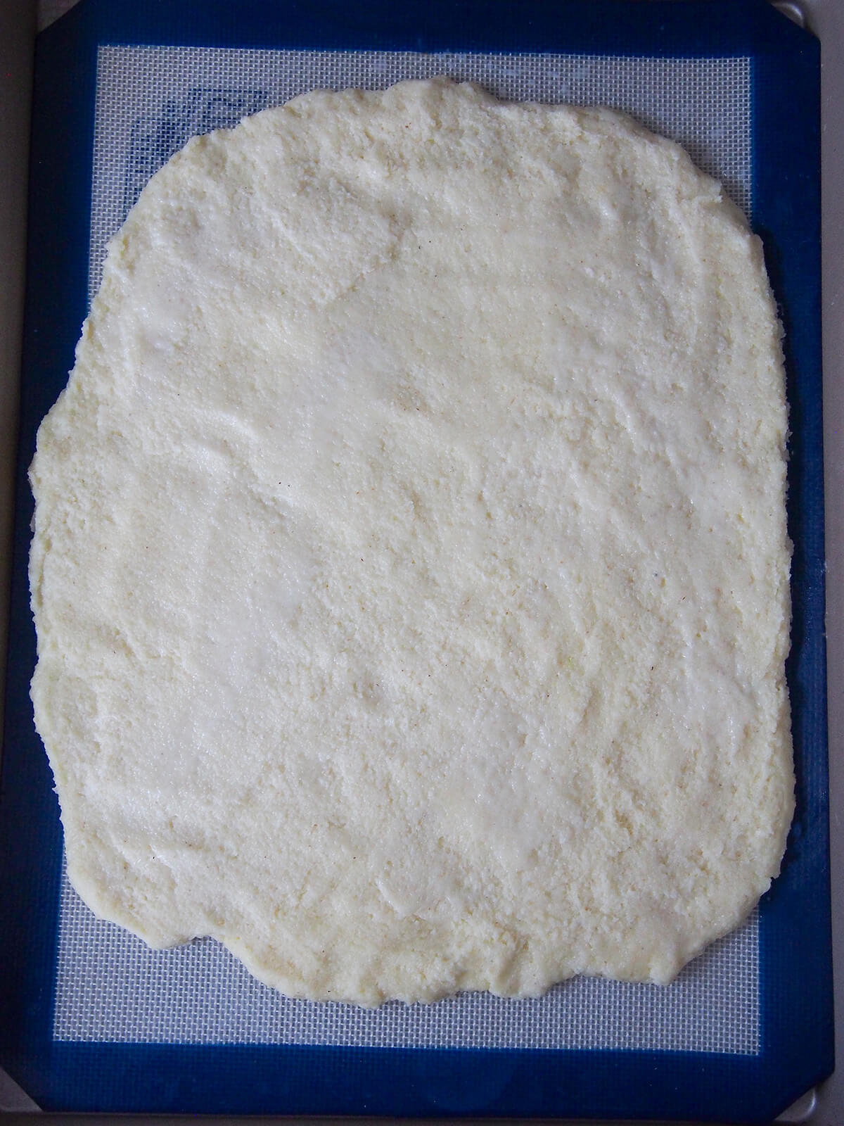 cooling a layer of semolina mixture on lined baking sheet.