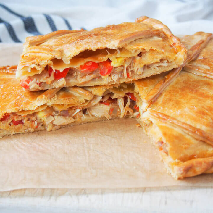 slice of empanada gallega sitting on top of more of pie.