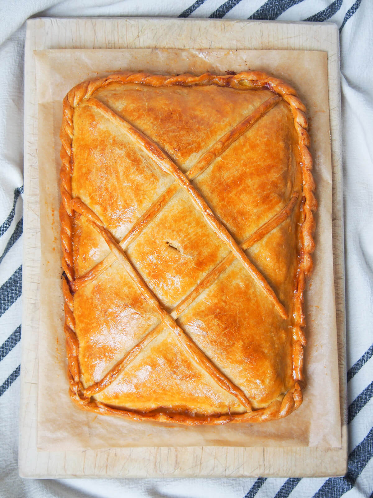 whole empanada gallega from overhead showing decoration on golden crust.