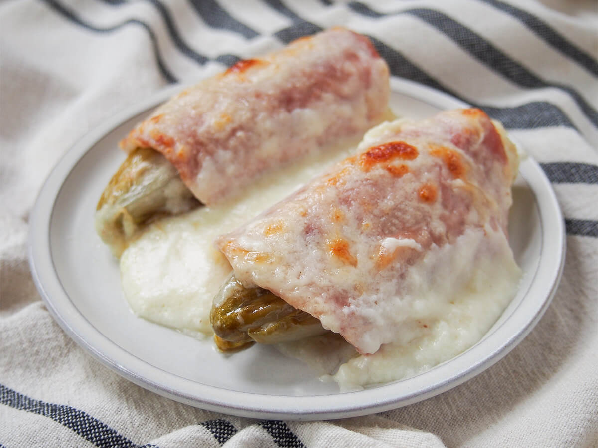two endives au jambon (Belgian endive gratin) on plate.