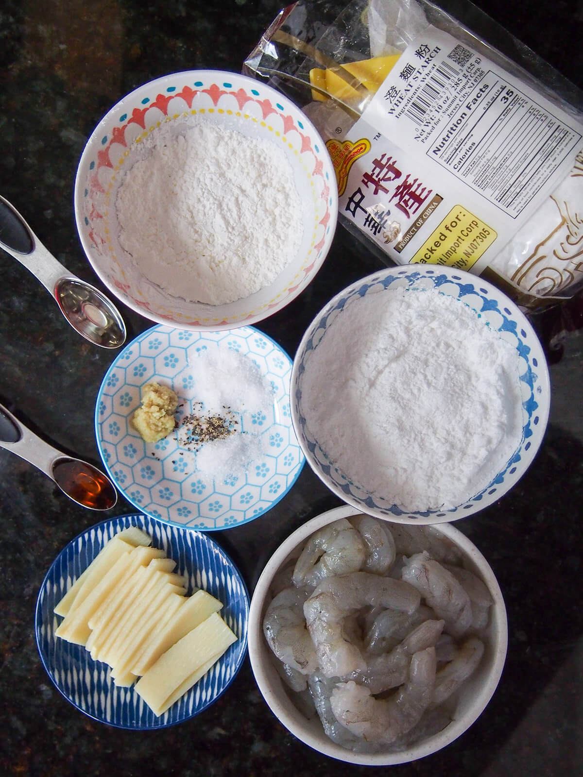 ingredients for har gow, shrimp dumplings bowls of corn starch, wheat starch, shrimp, bamboo shoots and bowl with seasonings.