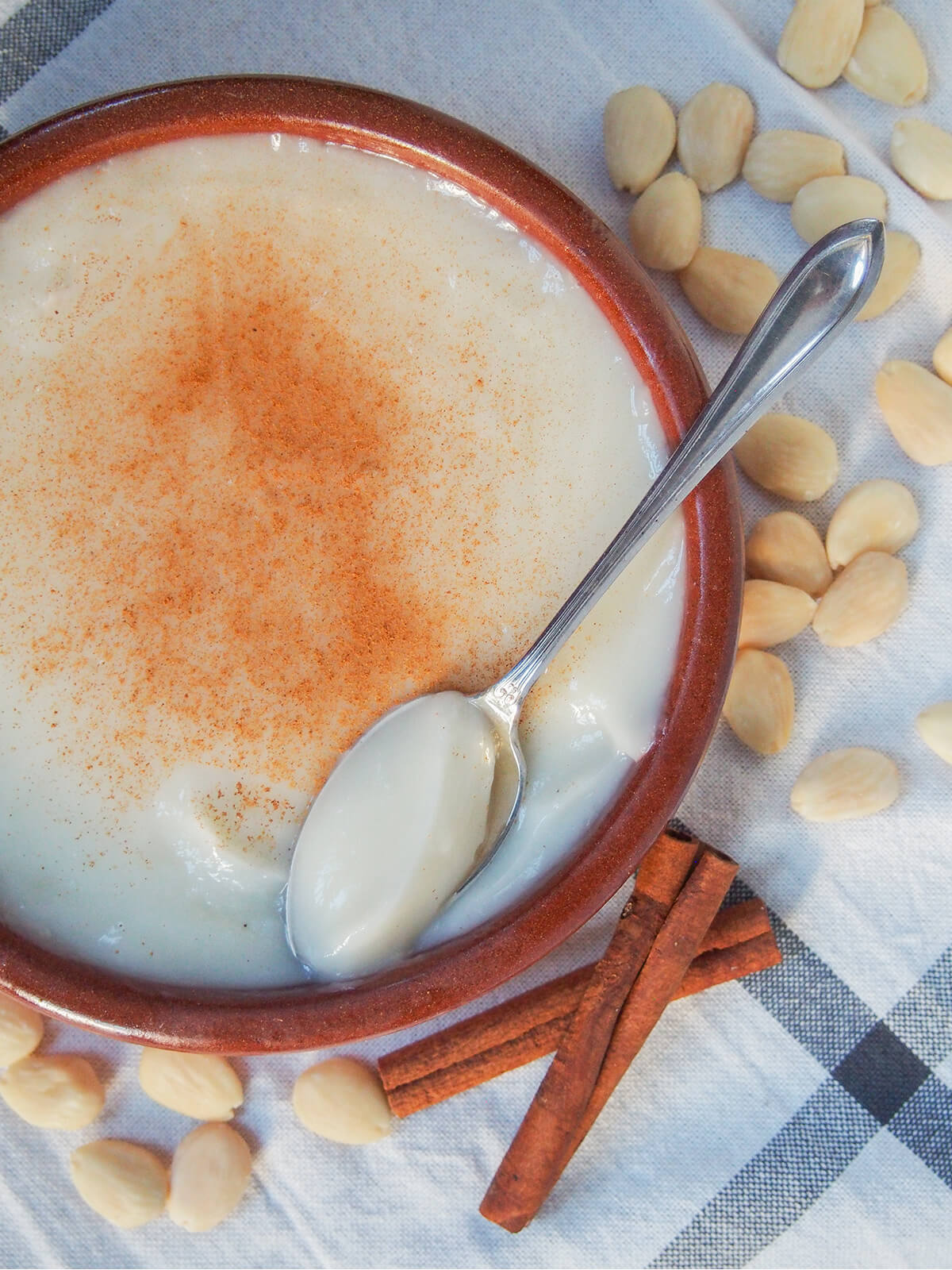 overhead view of dish with menjarblanc almond pudding with spoon on side of dish.