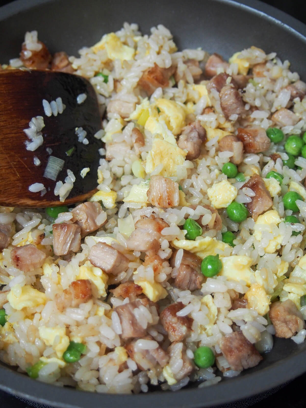 mixing chashu chahan, Japanese fried rice in skillet.
