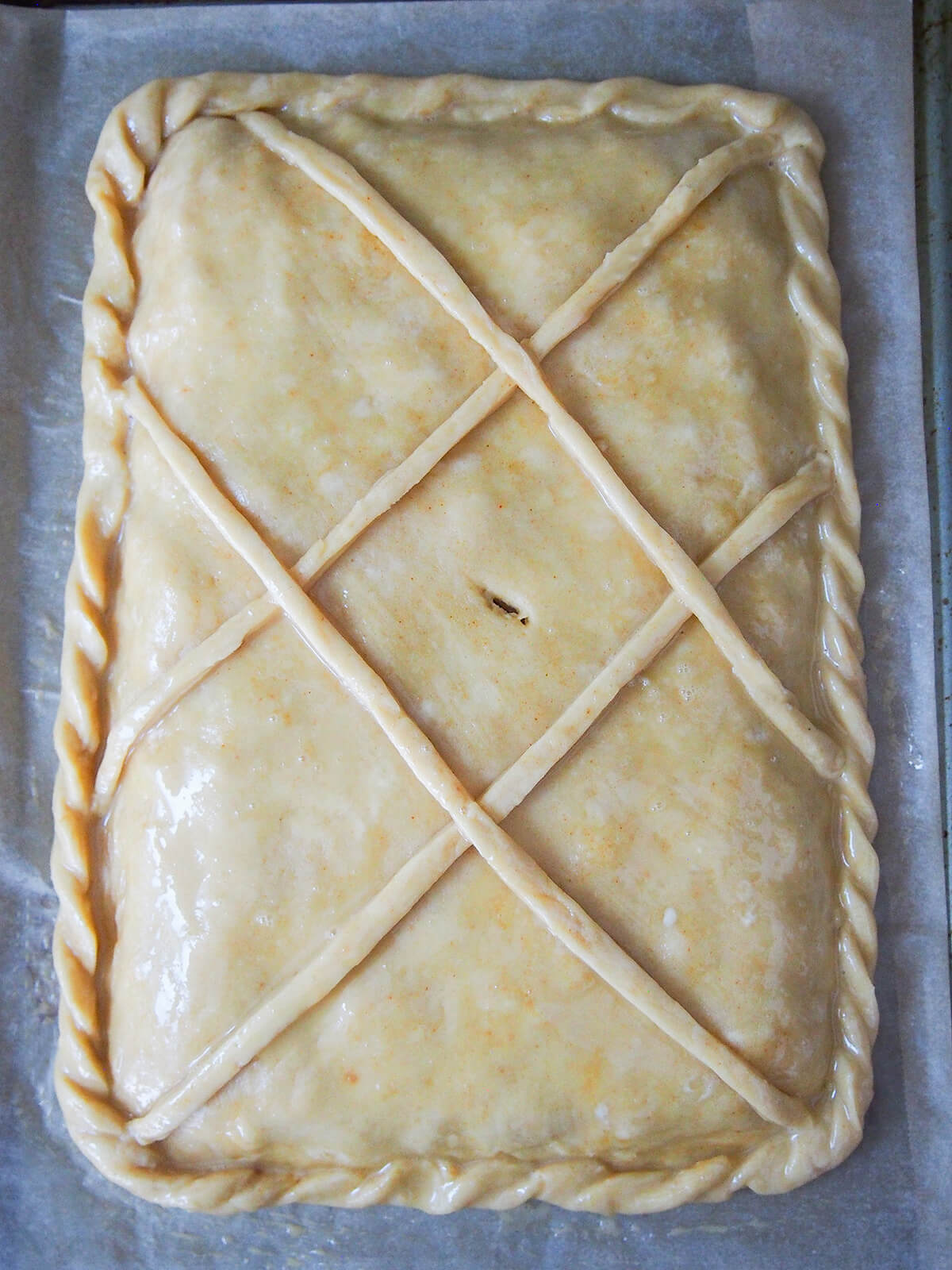 pie with decoration on top and egg wash before baking.