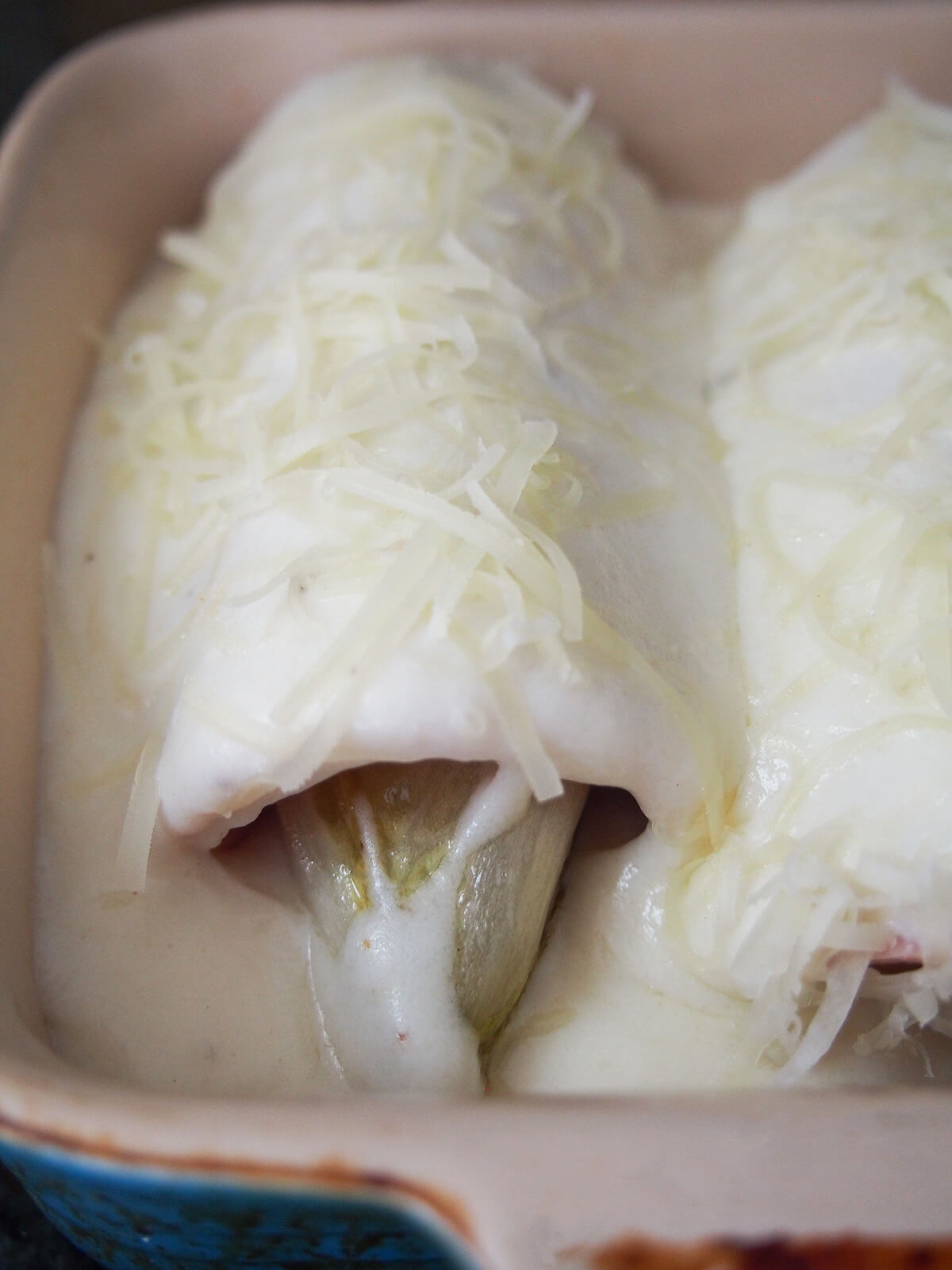 endive wrapped in ham and covered with Mornay sauce before baking.