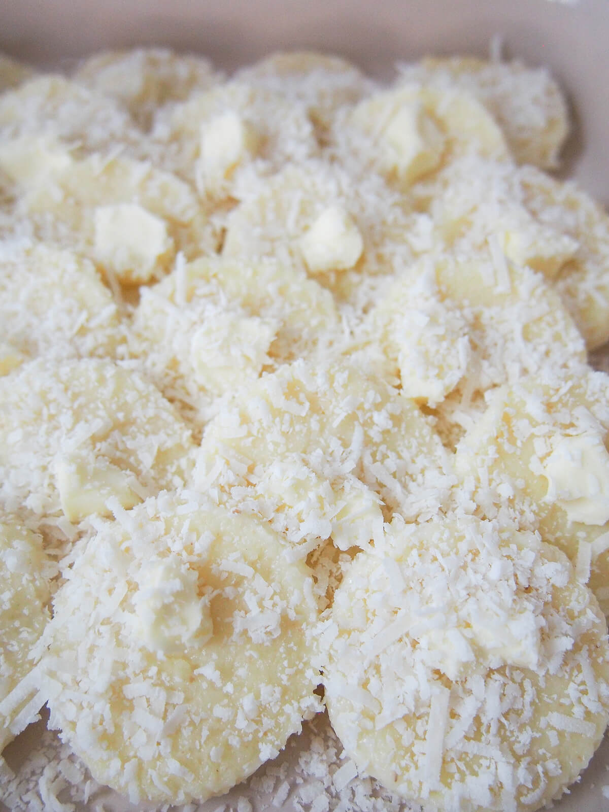 semolina gnocchi, gnocchi alla Romana topped with dots of butter and grated cheese before baking in oven.